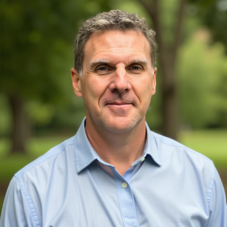 Mike Vanecek smiling outdoors in a light blue shirt